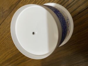 ヨーグルト容器に錐で1つ目の穴を開けている様子