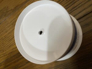 ヨーグルト容器の1つ目の穴をドライバーで広げている様子