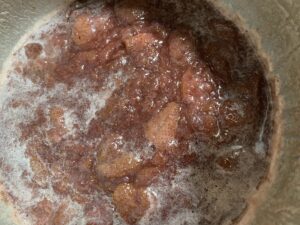 鍋でいちごと砂糖を混ぜながら加熱しているジャム作りの工程